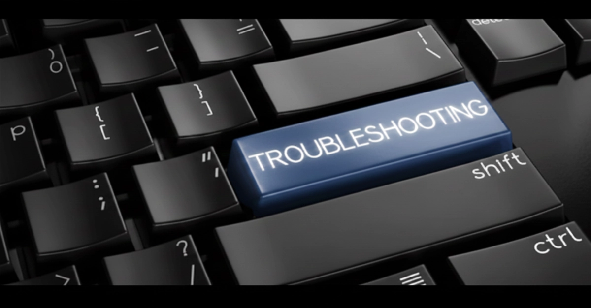 Gros plan sur un clavier d'ordinateur noir avec une touche bleue centrale marquée Troubleshooting pour résoudre les problèmes de performance informatique.